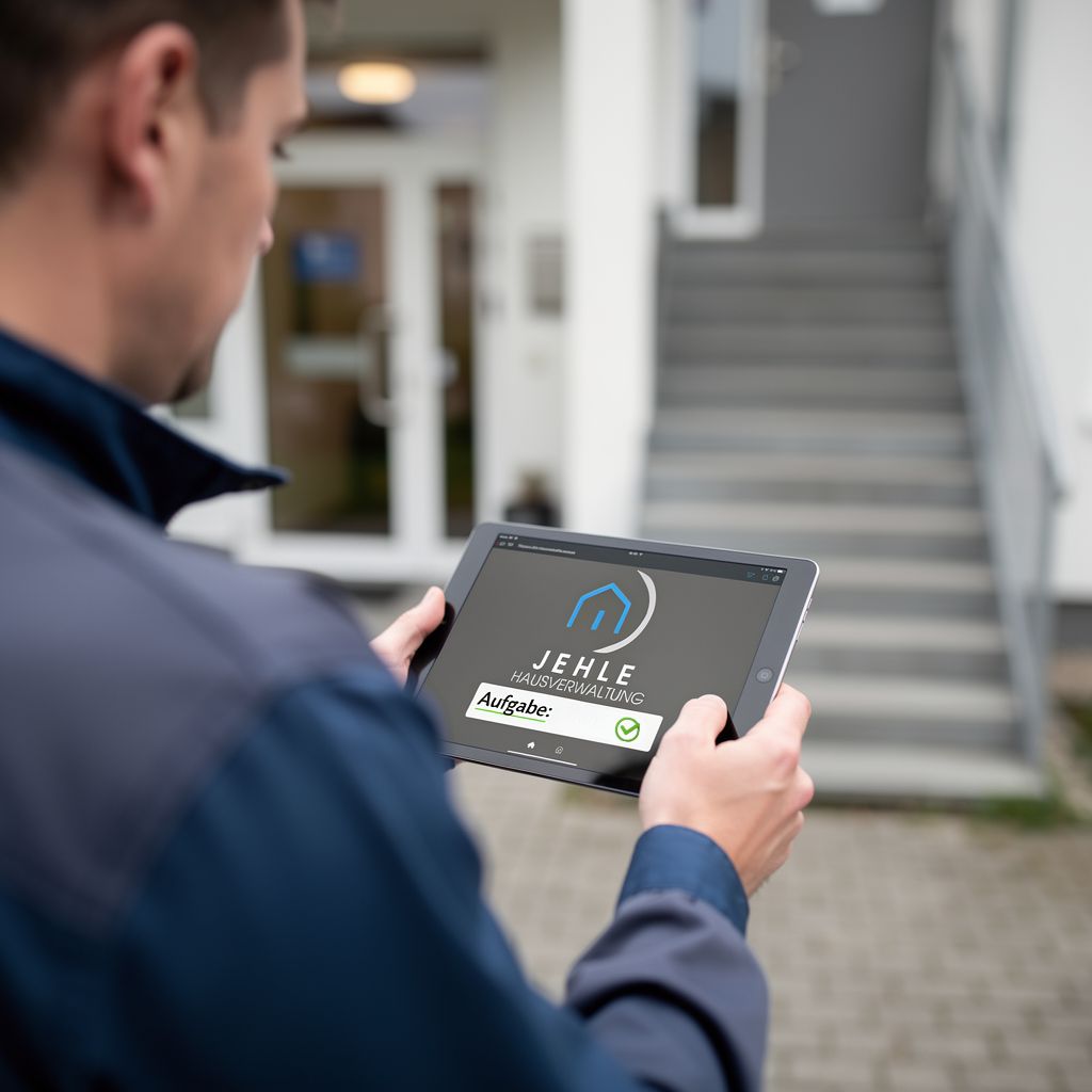 Mann mit neutralem Blick hält graues Tablet mit blauem Logo und Haken